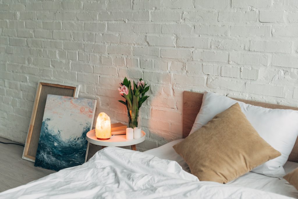 interior of bedroom with Himalayan salt lamp, flowers and candles